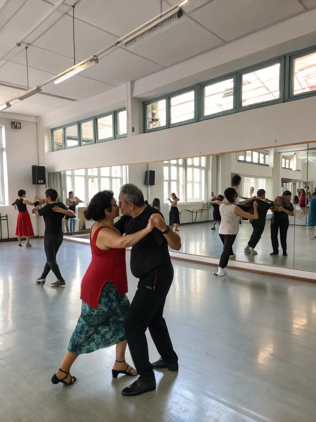 A vibrant image of a ballroom dance class in progress, showcasing various age groups learning classic dance steps with a professional instructor.